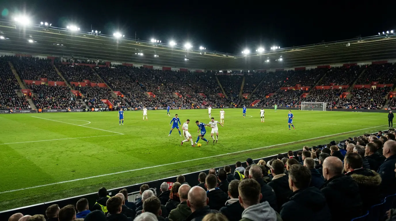 Aficionados viendo un partido de fútbol en vivo en un estadio iluminado de noche